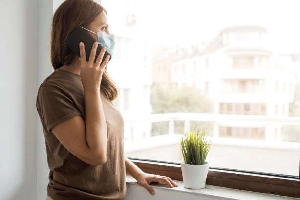 Woman indoors on phone showing signs of poor air quality at home